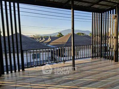 Spacious balcony with stunning mountain view and modern railing design.