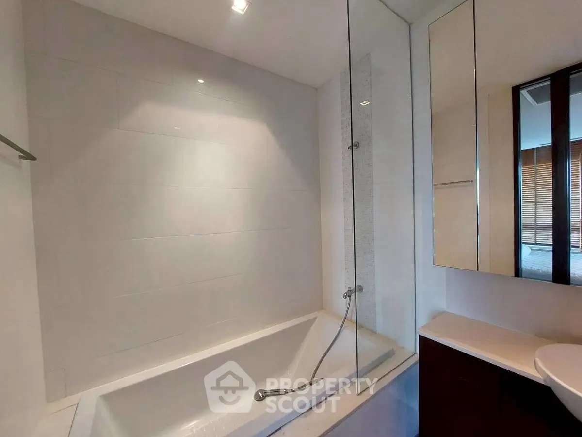 Modern bathroom with sleek bathtub and stylish fixtures in a contemporary apartment.