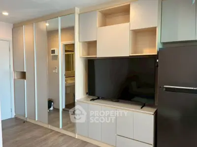 Modern living room with sleek cabinetry and large flat-screen TV