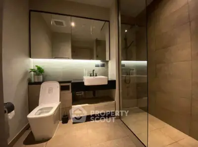 Modern bathroom with sleek design, featuring a glass shower and elegant fixtures.