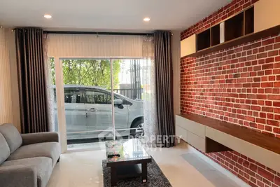 Modern living room with brick accent wall and large window overlooking car