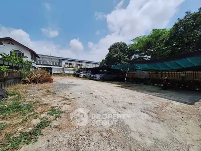 Spacious outdoor parking area with ample space and partial shade, ideal for vehicle storage or expansion.