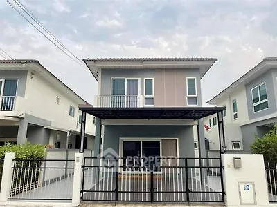 Modern two-story house with sleek design and spacious driveway in suburban neighborhood.