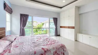 Spacious bedroom with large window and built-in wardrobe, offering a serene view and ample natural light.