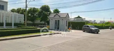 Charming residential entrance with lush greenery and secure gated access.