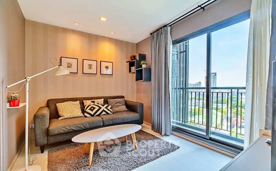 Modern living room with stylish decor and balcony view in a high-rise apartment.
