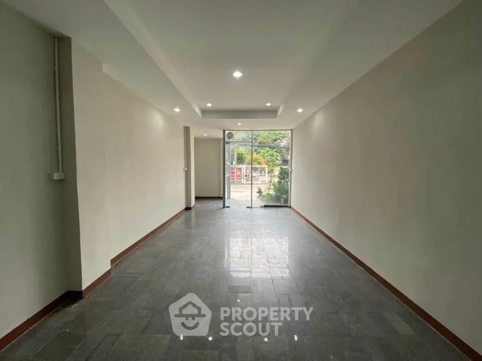 Spacious empty room with large windows and modern lighting, ideal for customization.