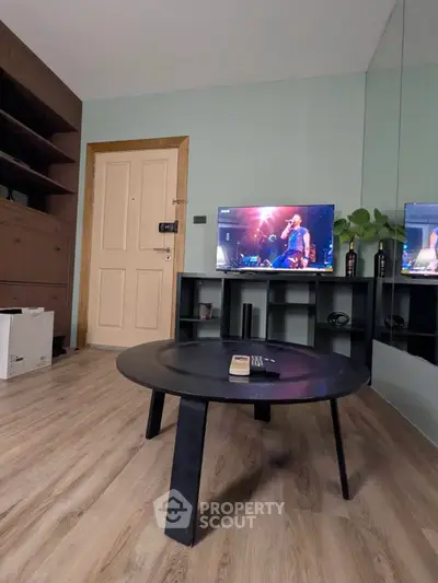 Modern living room with sleek black coffee table and wall-mounted TV