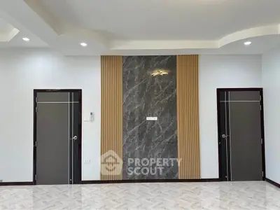 Modern interior with elegant wall design and two doors, featuring stylish lighting and marble accents.