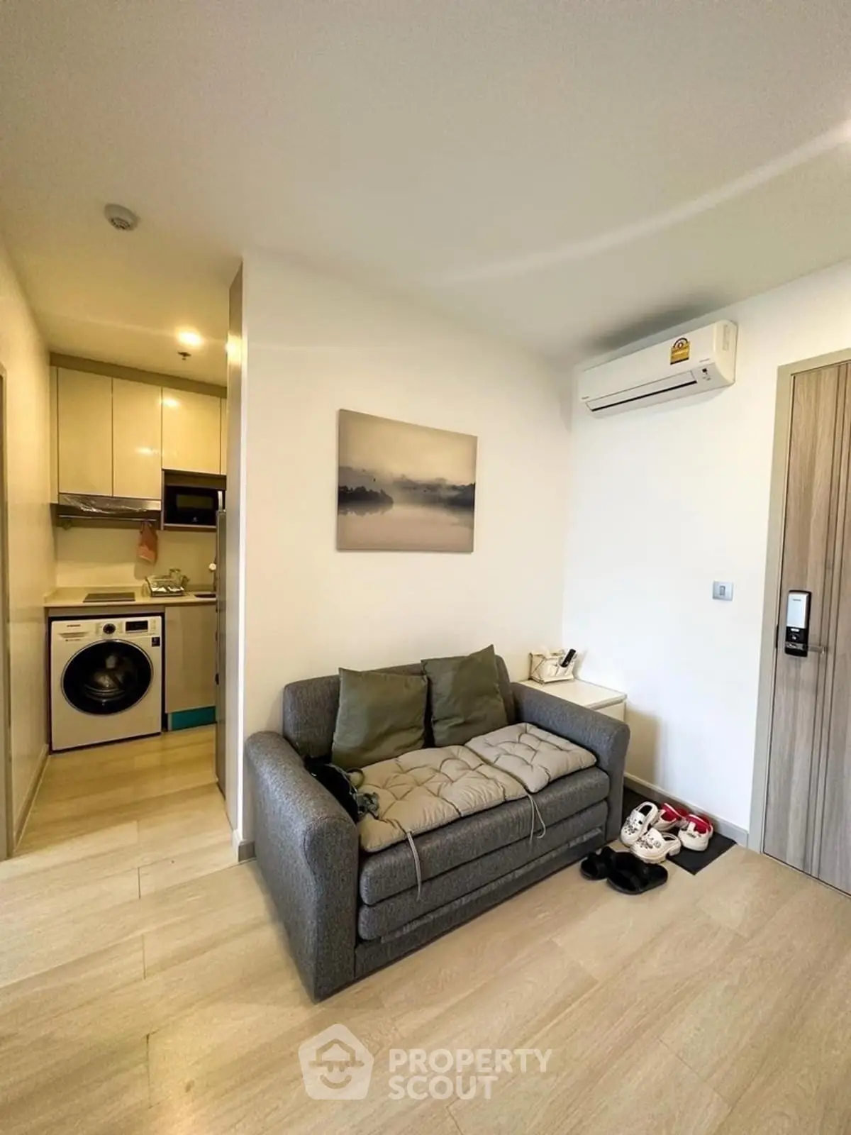 Cozy living room with modern kitchen and washing machine in compact apartment