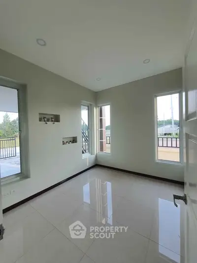 Bright and airy room with large windows and balcony access, perfect for a serene living space.