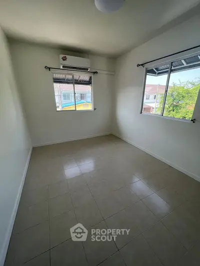 Bright empty room with tiled floor and air conditioning, perfect for customization.