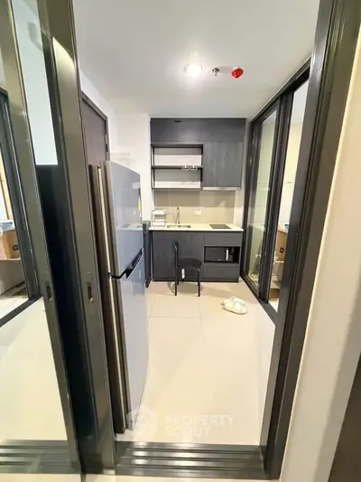 Modern compact kitchen with sleek appliances and open layout in a stylish apartment.