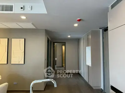 Modern apartment interior with sleek design and neutral tones, featuring hallway and partial living area view.