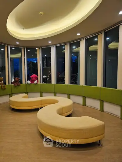 Modern circular seating area with plush toys and large windows