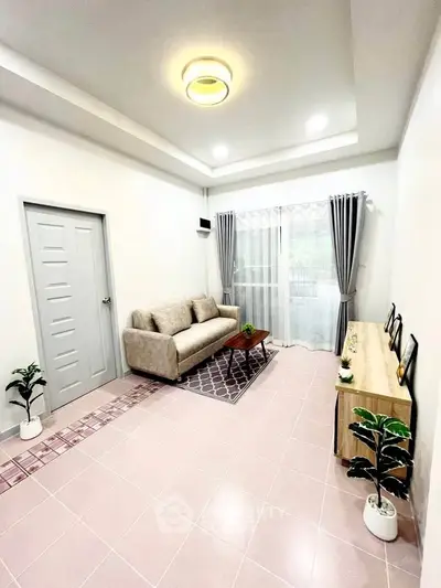 Modern living room with cozy sofa, stylish decor, and natural light from large window.