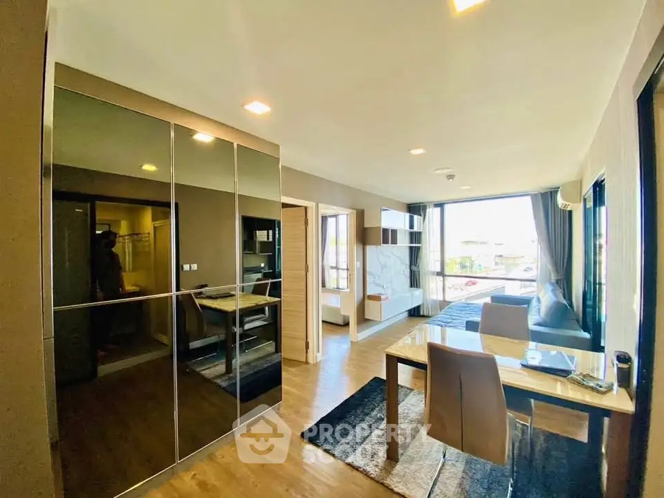 Modern living room with sleek design, large windows, and stylish furniture in a contemporary apartment.