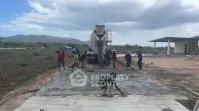 Construction workers pouring concrete for a new driveway in a residential area.