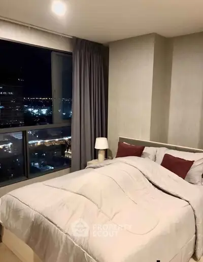 Luxurious bedroom with city view, cozy bedding, and ambient lighting for a serene night retreat.
