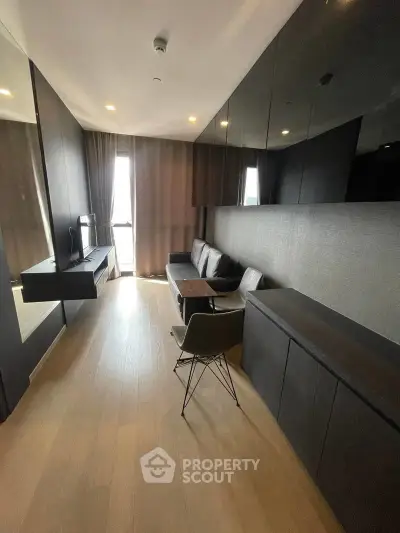 Modern living room with sleek black furniture and floor-to-ceiling windows