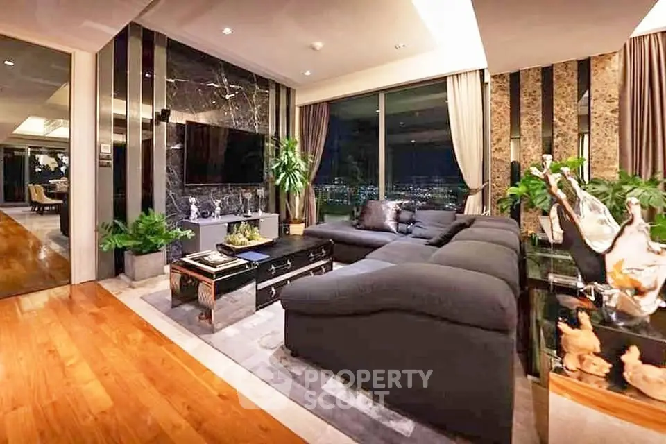 Luxurious living room with panoramic city view, elegant decor, and plush seating in a high-rise apartment.