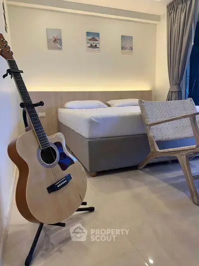 Cozy bedroom with guitar and stylish chair, perfect for music lovers.