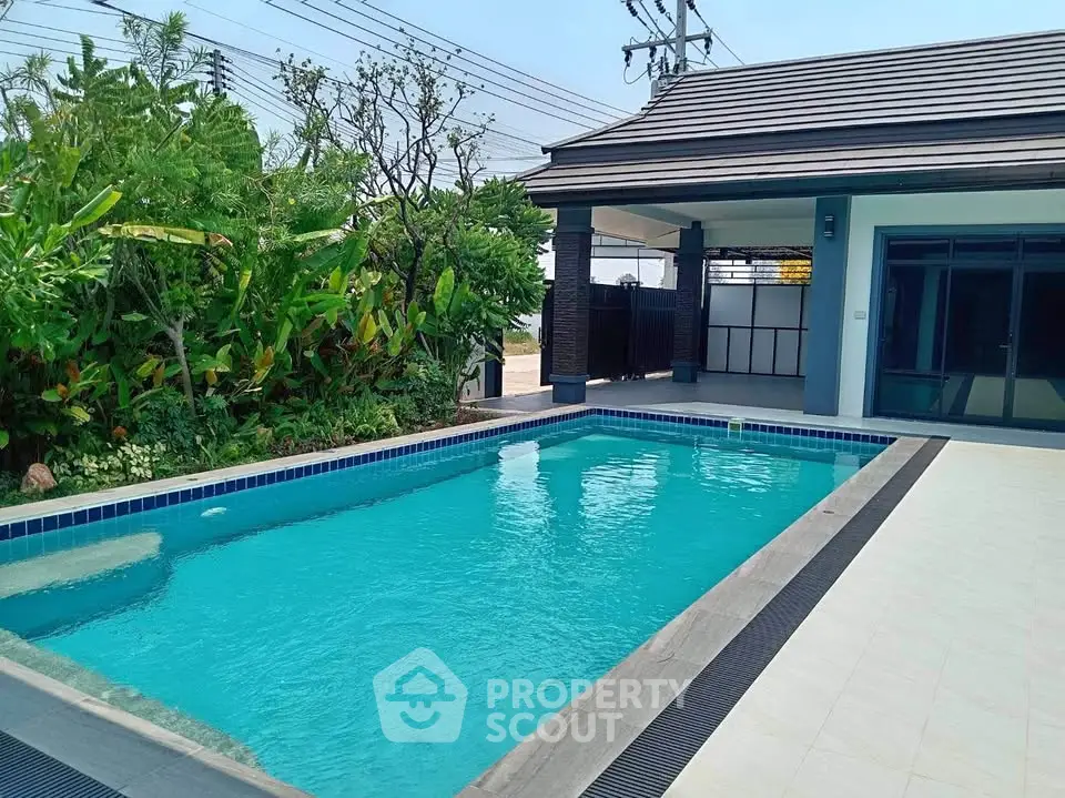 Luxurious private pool with lush greenery and modern patio, perfect for relaxation and entertainment.