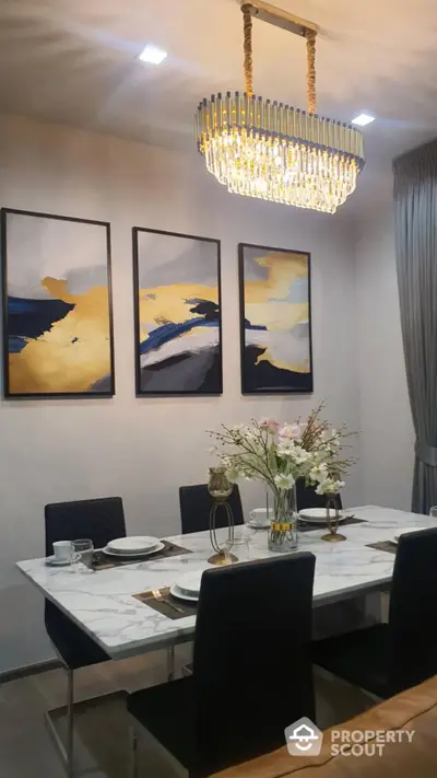 Elegant dining room with modern chandelier and abstract art decor