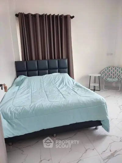 Cozy bedroom with modern decor and elegant curtains, perfect for relaxation.