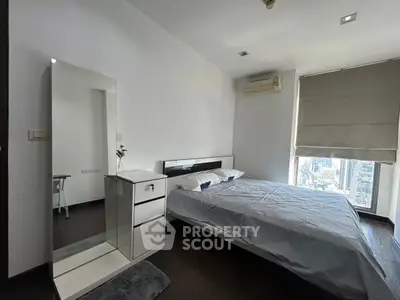 Modern bedroom with city view, featuring sleek furniture and air conditioning, perfect for urban living.