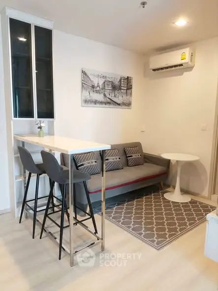 Modern living room with stylish decor and cozy seating area, featuring a sleek air conditioning unit.