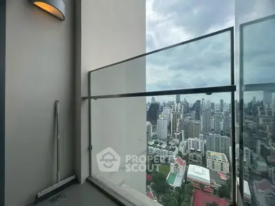 Stunning cityscape view from a modern high-rise balcony with glass railing.