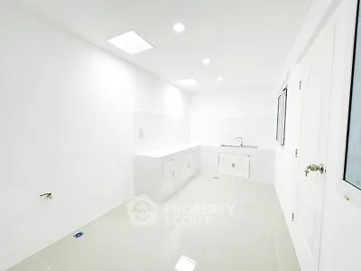 Spacious white kitchen with modern fixtures and ample storage space