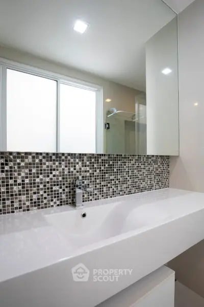 Modern bathroom with sleek sink and mosaic tile backsplash