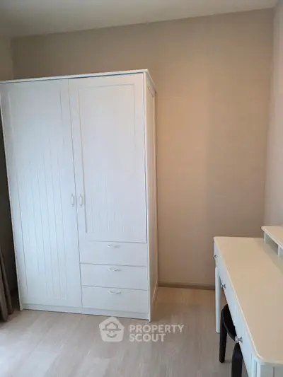 Bright bedroom with white wardrobe and desk, perfect for modern living.