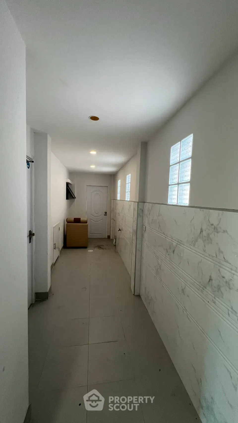 Spacious hallway with modern marble wall accents and natural light.
