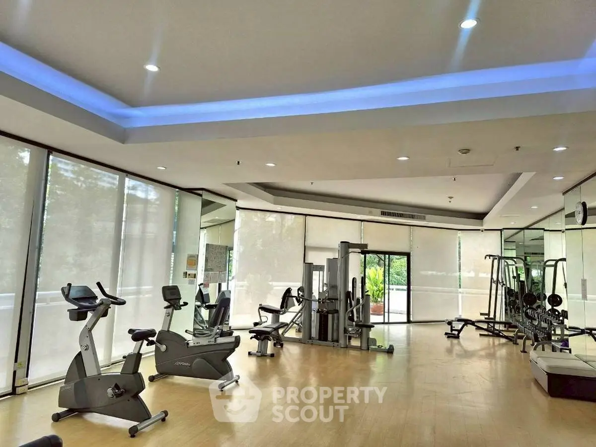 Spacious modern gym with state-of-the-art fitness equipment and natural lighting.