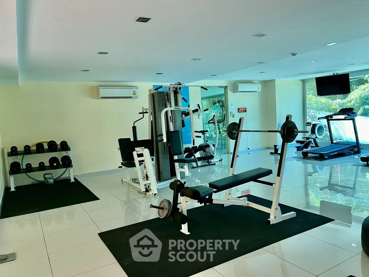 Spacious gym with modern fitness equipment and bright natural lighting