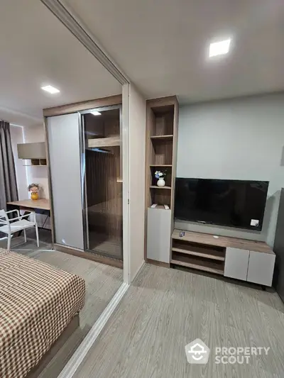 Modern bedroom with sliding wardrobe and TV unit in stylish apartment