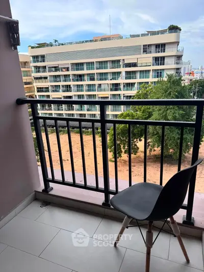 Charming balcony view with modern chair overlooking urban landscape and contemporary building.