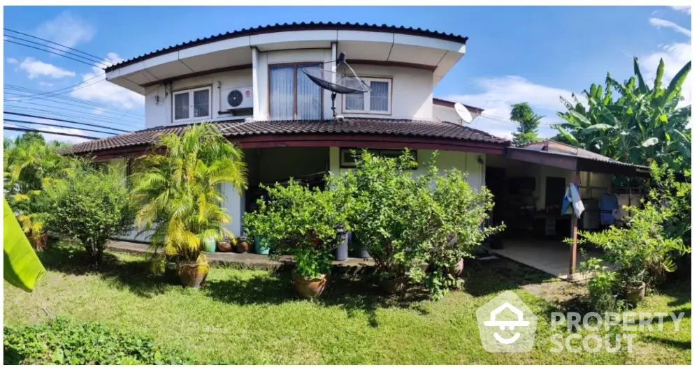 Charming two-story house with lush garden and spacious outdoor area, perfect for family living and relaxation.