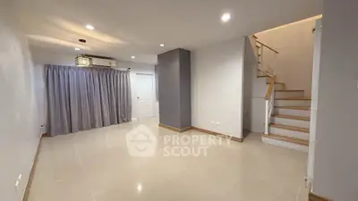 Spacious modern living room with staircase and elegant lighting