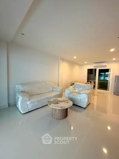 Spacious modern living room with sleek furniture and glossy tiled floors
