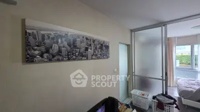 Cozy bedroom with sliding glass doors and cityscape artwork, offering a bright and inviting atmosphere.
