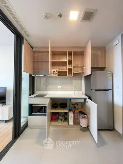 Modern kitchen with open cabinets, sleek appliances, and ample storage space in a stylish apartment.