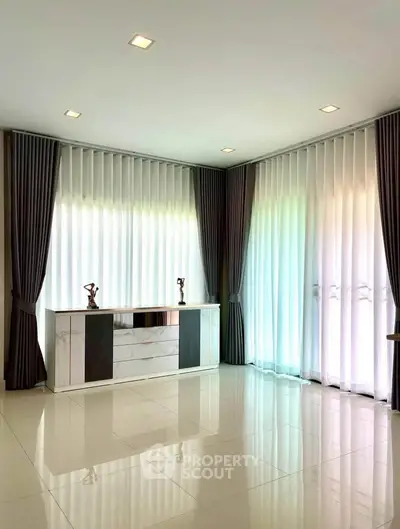 Spacious modern living room with sleek marble console and floor-to-ceiling windows.