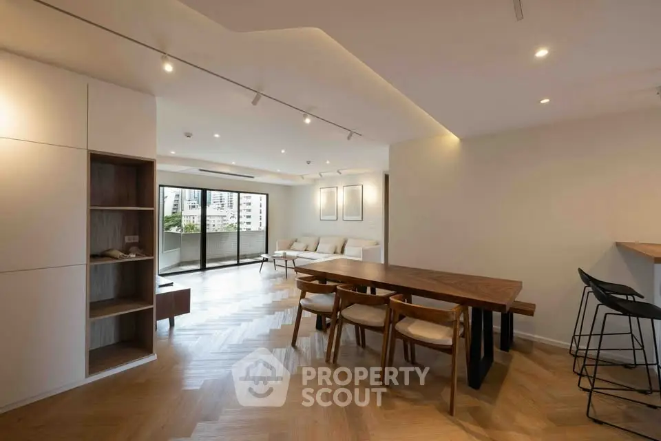 Spacious modern living room with elegant dining area and city view balcony.