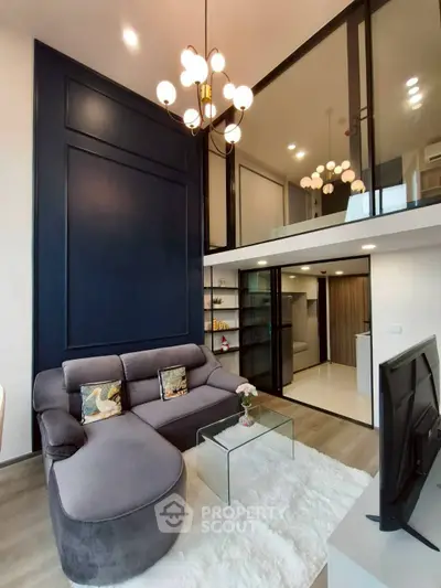 Modern living room with high ceiling and elegant chandelier in a stylish apartment.