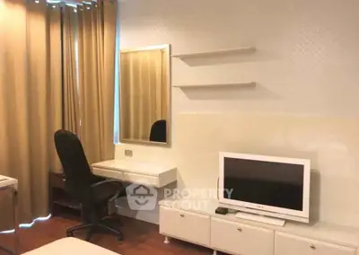 Modern bedroom with sleek furniture, wall-mounted TV, and elegant curtains for a cozy living space.