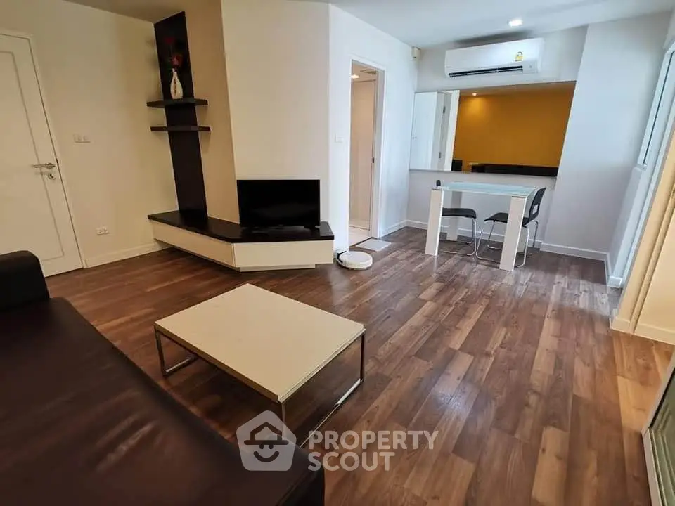 Modern living room with sleek furniture and wooden flooring in a stylish apartment.